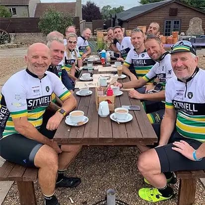 A photograph of club members sat around a table